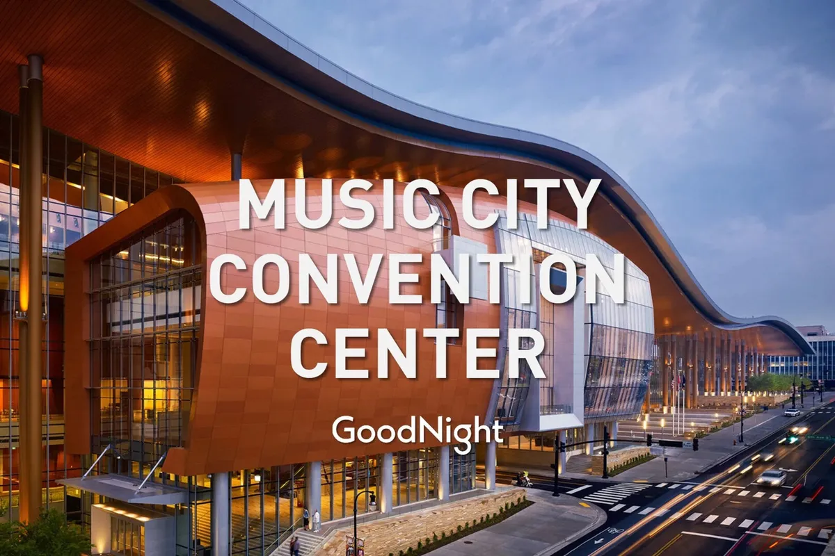 This image features the curved, modern facade of the Music City Convention Center with a large glass entrance area. The scene captures a sense of energy and movement, emphasizing the building's significance as a hub for conventions and events in Nashville.