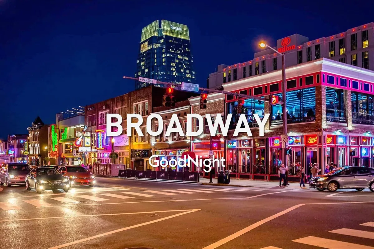 A vibrant Nashville street scene at night, featuring colorful neon signs, busy streets, and people out and about exploring nightlife venues. High-rise buildings and traffic lights add to the energy and urban excitement.